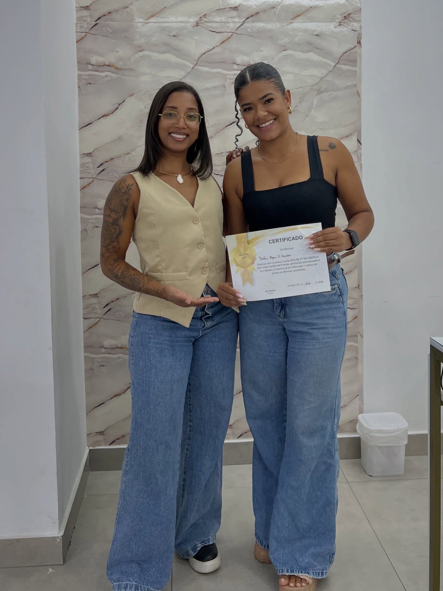 Ana Beatriz com uma aluna segurando seu certificado